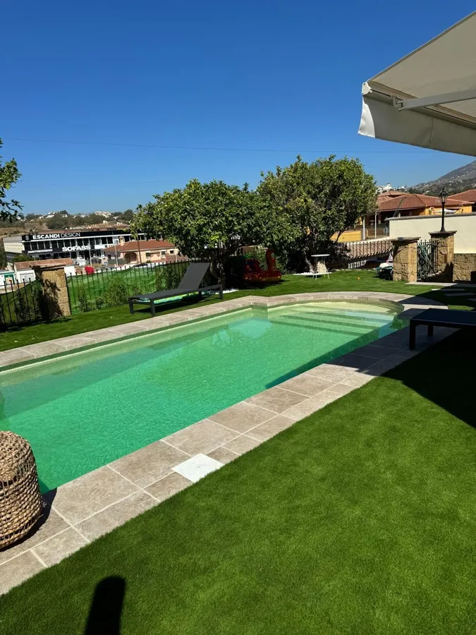 Piscina con jardín y zona de tumbonas en Mijas