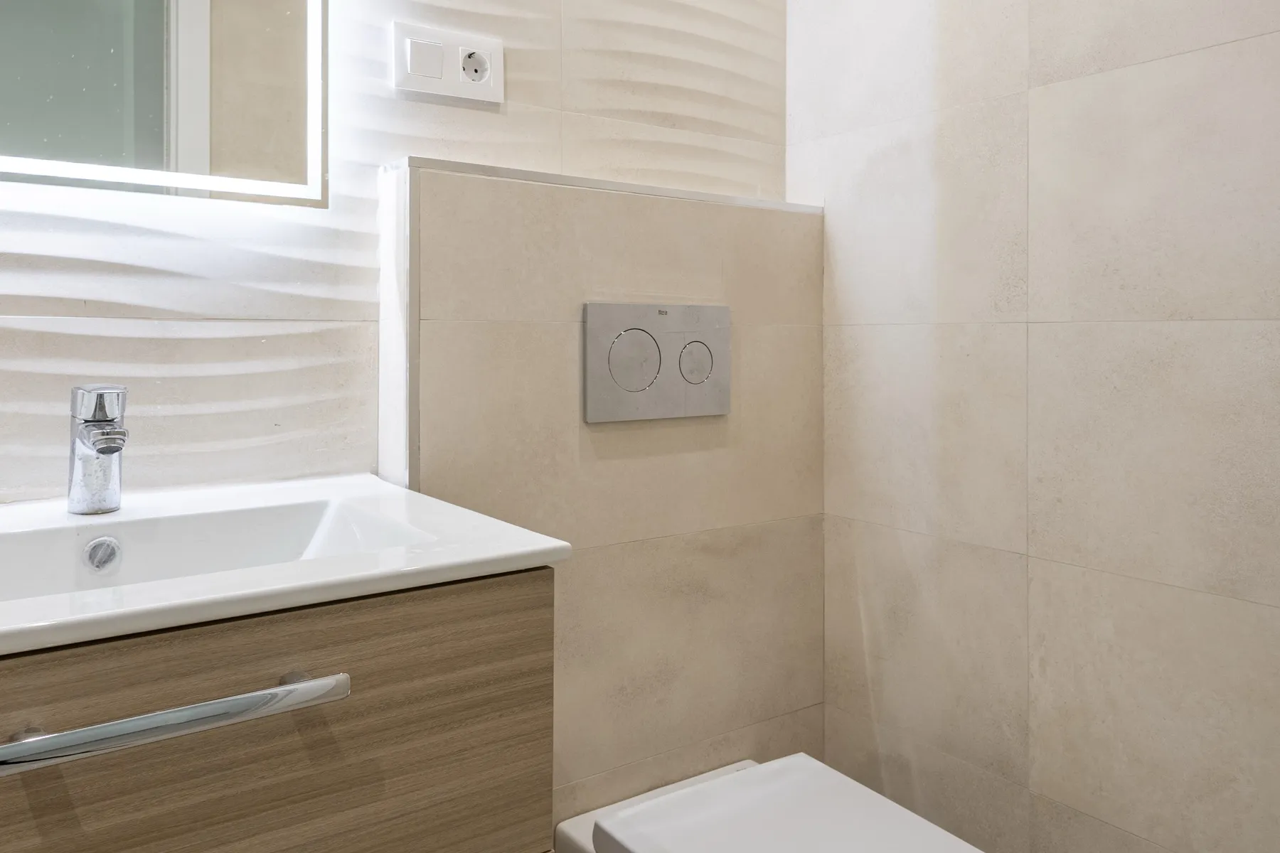 Baño con mueble suspendido y espejo con luz LED, reforma Fuengirola