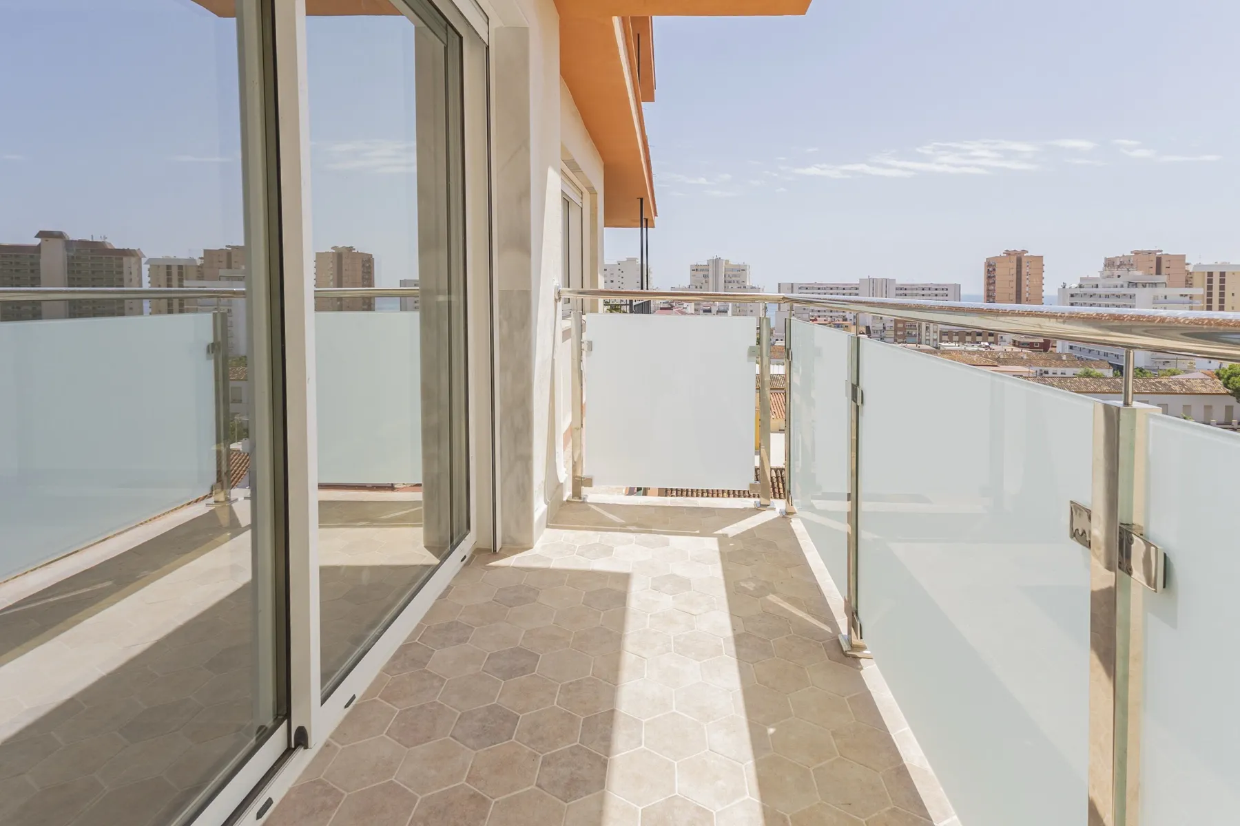 Terraza alargada con suelo hexagonal y vistas al mar, reforma en Fuengirola