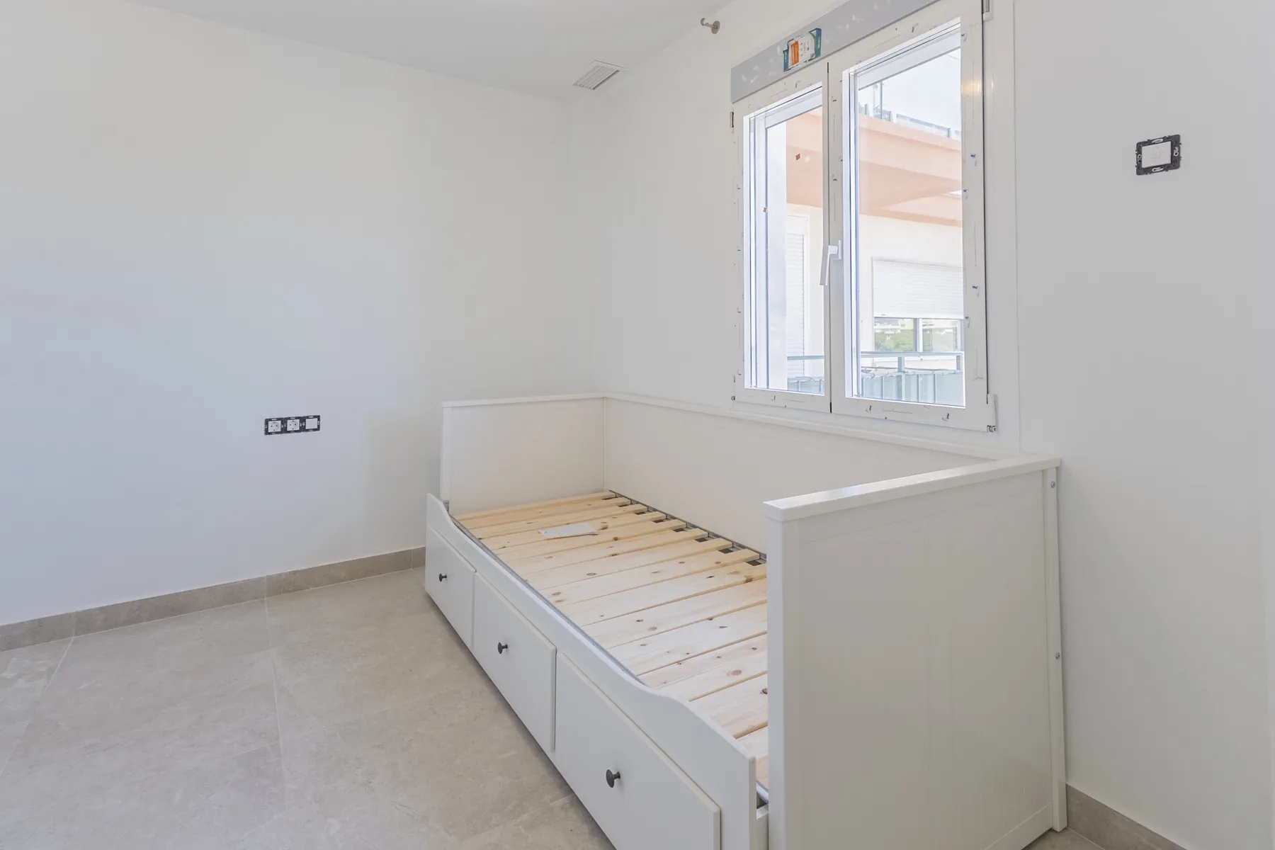 Dormitorio con cama junto a la ventana, piso reformado en Fuengirola