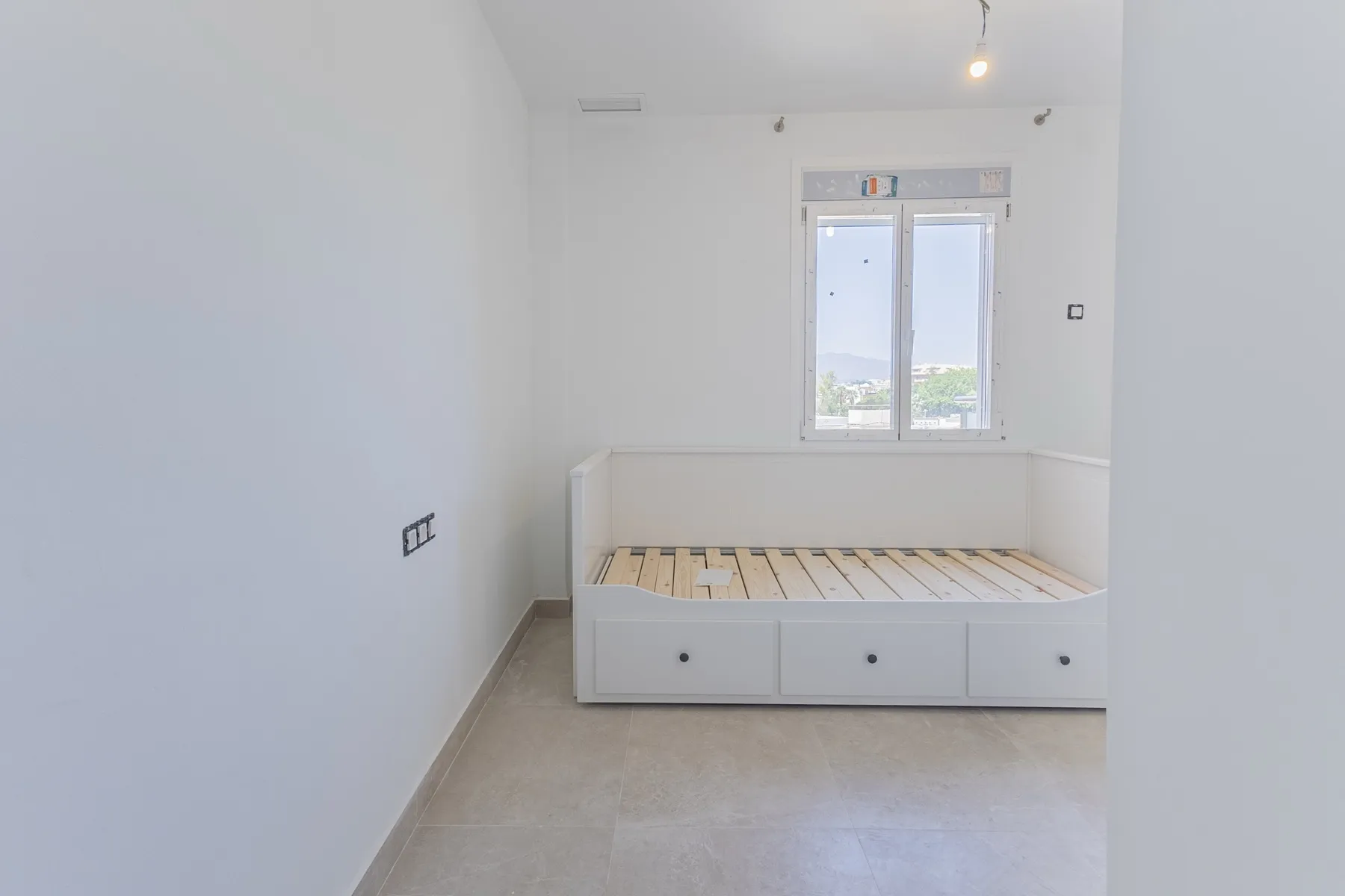 Dormitorio con vistas a la ciudad, reforma de piso en Fuengirola