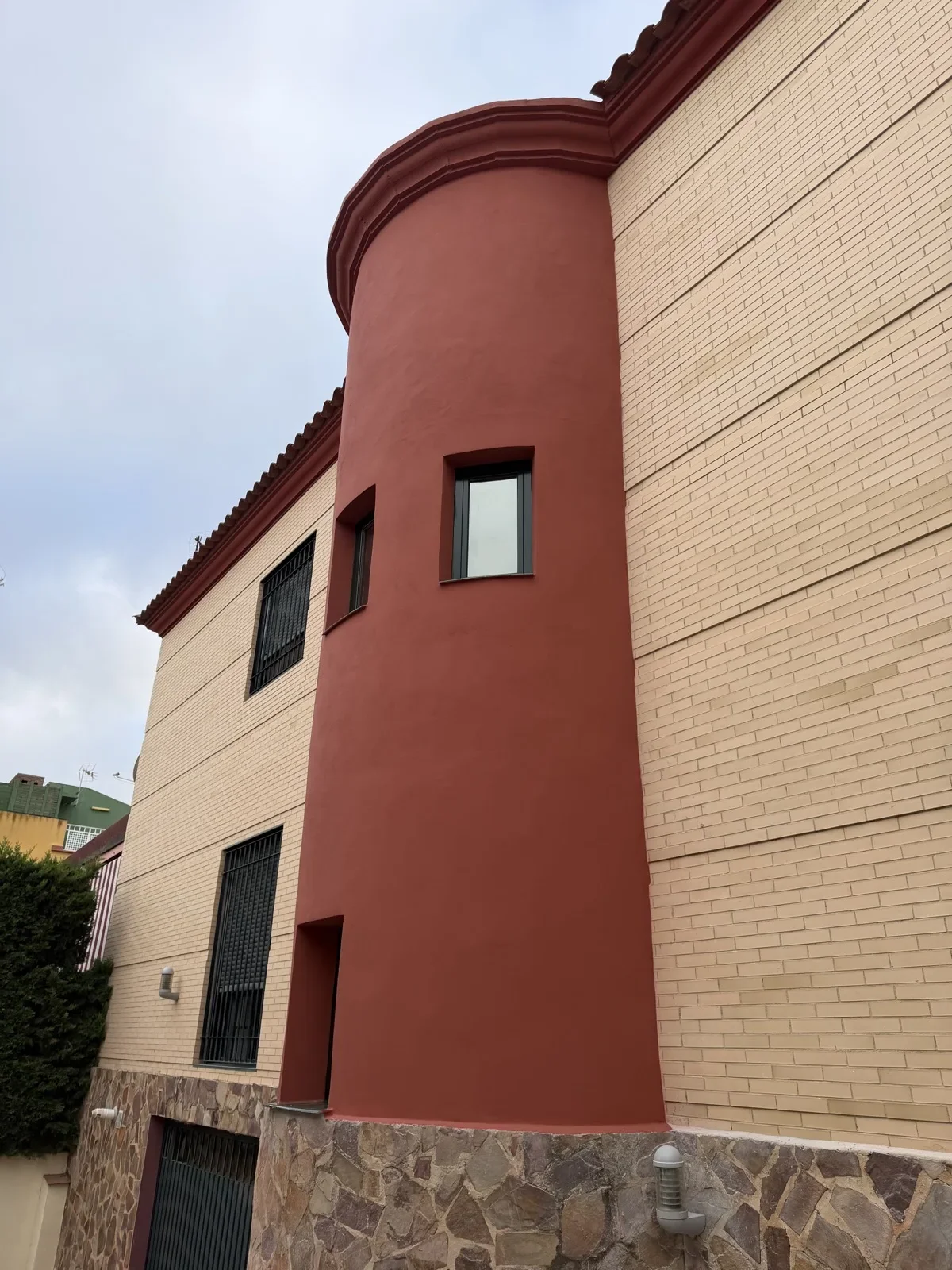 Misma fachada terminada, con ventanas nuevas y monocapa roja