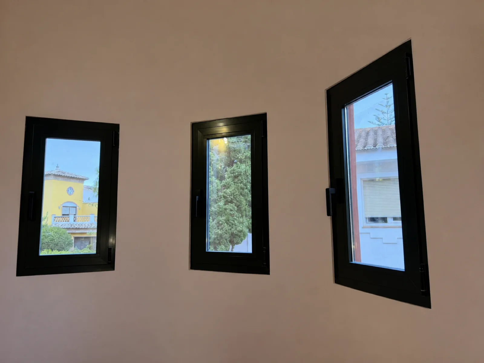 Tres ventanas nuevas de PVC vistas desde el interior de la torre en Guadalmar
